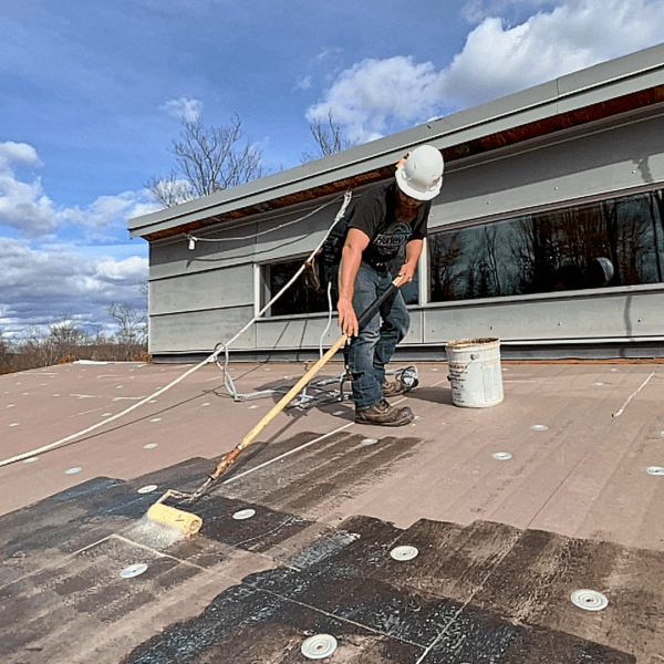 Roofer Applying Commercial Roofing Materials To Low Slope Roof