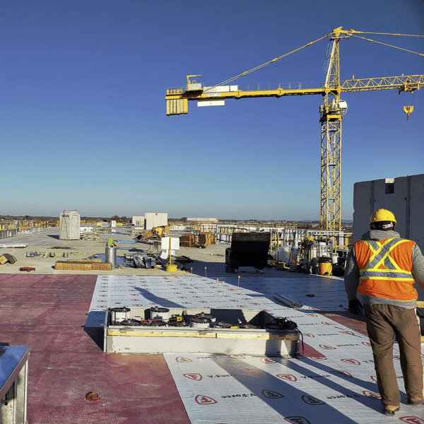 Commercial Roofer Looking Over Massive Flat Roof Construction