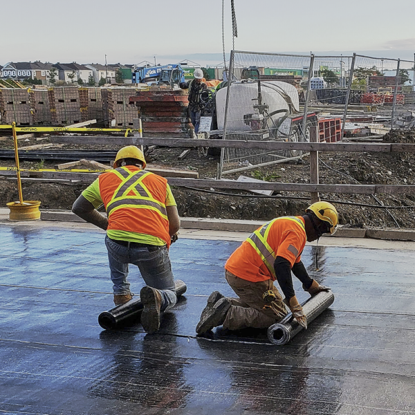 Roofers Working With Commercial Roofing Materials For New Flat Roof Construction